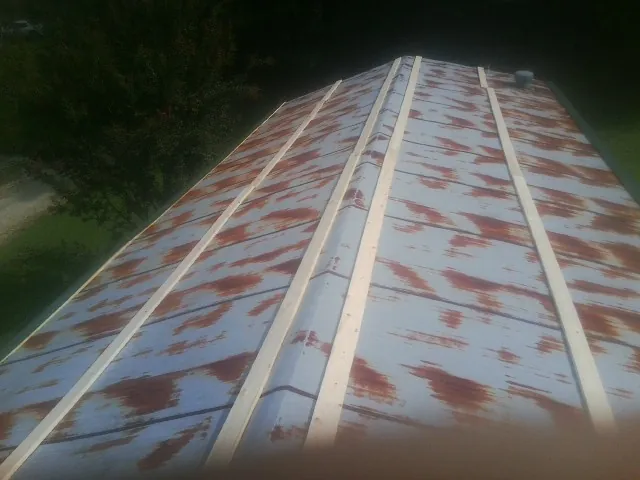 Rusted metal roof panels with new wood purlins before replacement — Storm Damage Roof Repair in Palm Beach Gardens by Roofing Brothers
