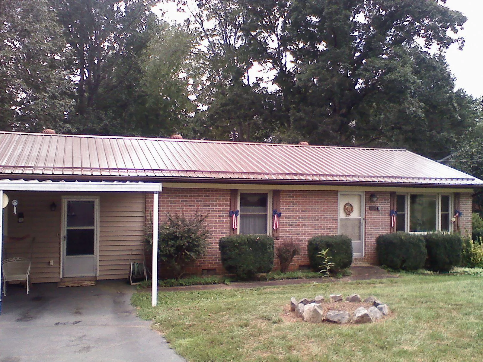 Bronze metal roof and carport on a brick ranch home — Roof Repair work by our crew in Palm Beach Gardens